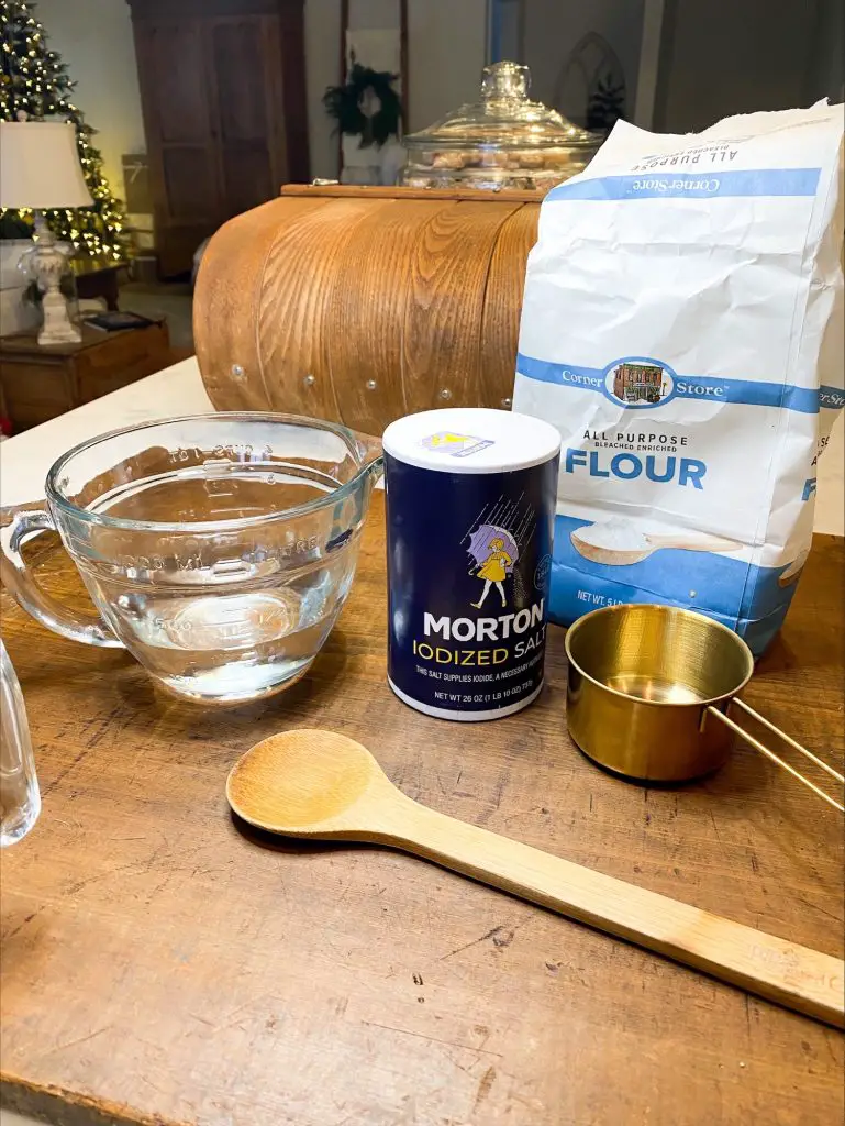 salt dough ingredients, salt, flour, water, 1 cup measuring cup and wooden spoon