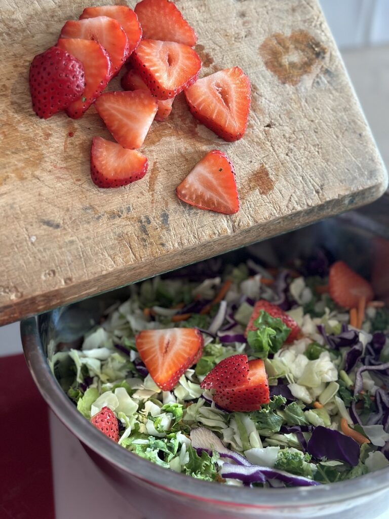 Mixing strawberries with salad mix